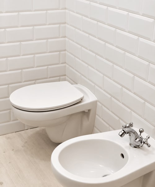 Angolo bagno bianco moderno con wc sospeso, lavabo circolare e rubinetteria cromata presso l'hotel boutique HABITARE Lecce