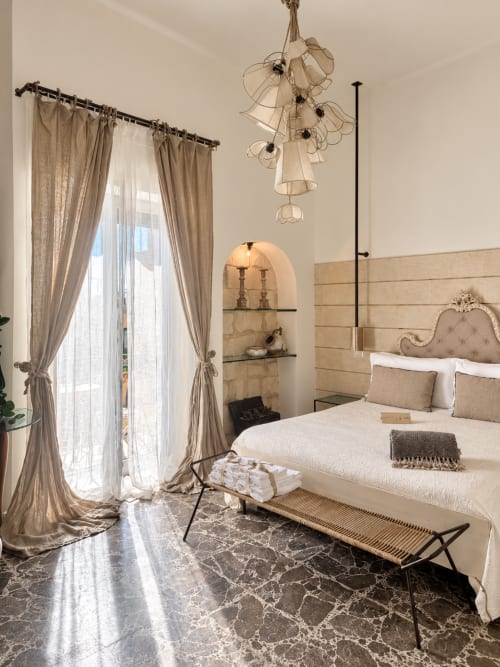 Camera elegante di HABITARE Lecce con pavimento in marmo, arredamento beige, luce naturale dal balcone e lampada decorativa