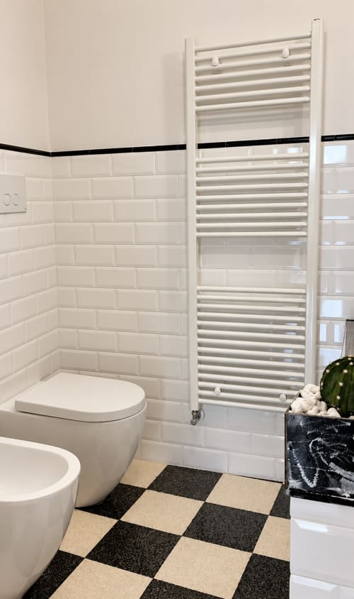Bagno moderno all'HABITARE Lecce con piastrelle bianche, scaldasalviette, pavimento a scacchiera e cactus in vaso nel Salento