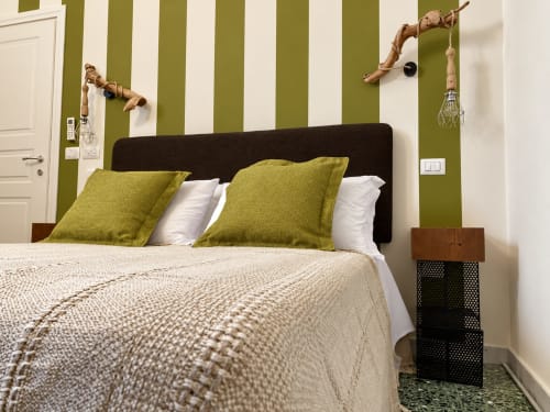 Olivum Double Room at HABITARE Lecce with olive-striped walls, black headboard, chartreuse pillows, and wooden bedside table