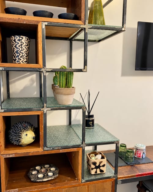Decorative shelving unit with plants, a cactus, candles, and home décor in HABITARE Lecce hotel room