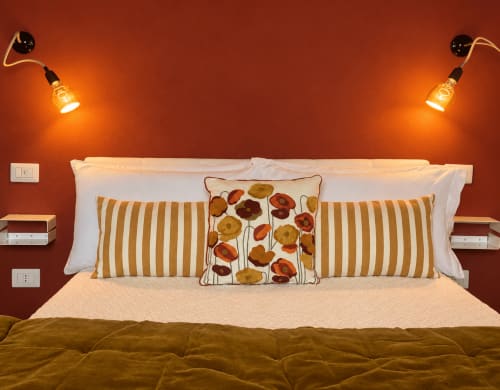 Rubrum cozy double room at HABITARE Lecce, red accent wall with striped pillows and floral cushions