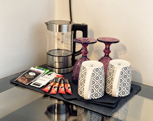 Cozy room welcome setup at HABITARE Lecce with kettle, coffee, decorative cups, and amenities tray