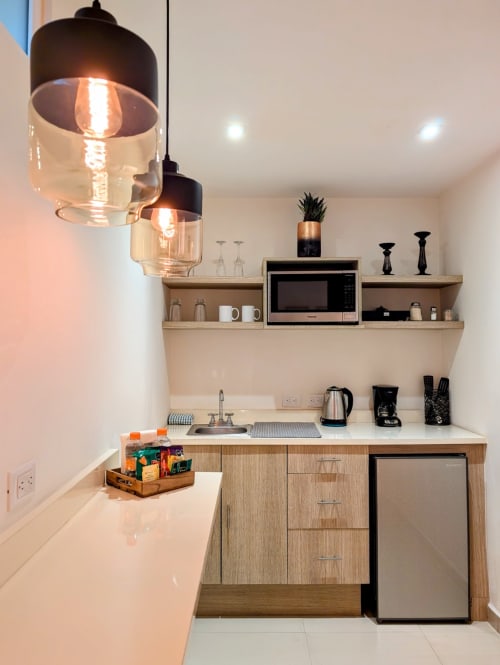 Pequeña cocina moderna en Casa Donceles con iluminación colgante, microondas, minibar y encimeras blancas