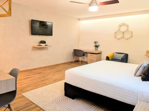 Habitación moderna en Casa Donceles, Ciudad de México, con cama king, televisor de pared, pisos de madera, zona de trabajo
