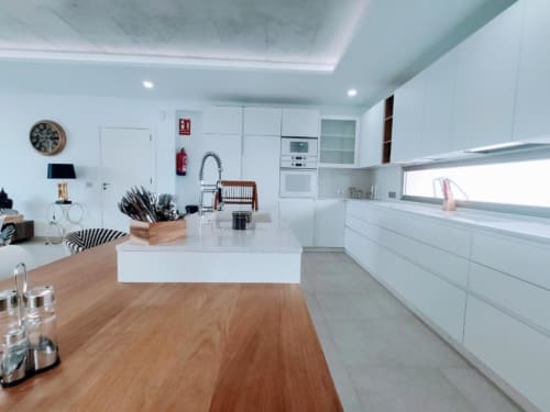 Modern white kitchen with wooden counter, white cabinetry, and stainless steel appliances in Manage Home Tenerife apartment,
