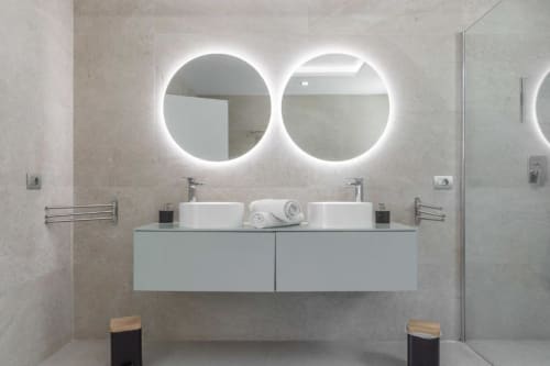 Modern luxury bathroom at Manage Home Tenerife with dual vessel sinks, illuminated circular mirrors, and sleek vanity in