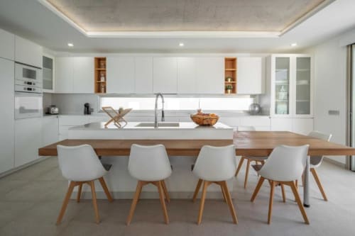 Modern kitchen and dining area in Manage Home Tenerife apartment, Costa Adeje with white cabinetry and wooden table