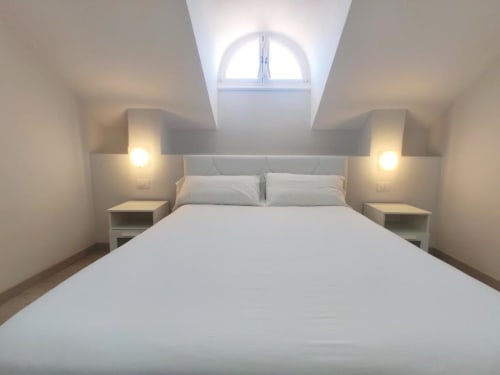 Modern bedroom with skylight in Playa de las Américas apartment featuring queen bed and twin nightstands