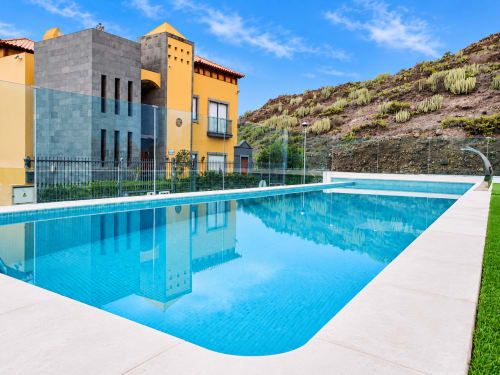 Modern apartment with pool view at Manage Home Tenerife, Costa Adeje. Contemporary buildings overlook crystal-clear swimming