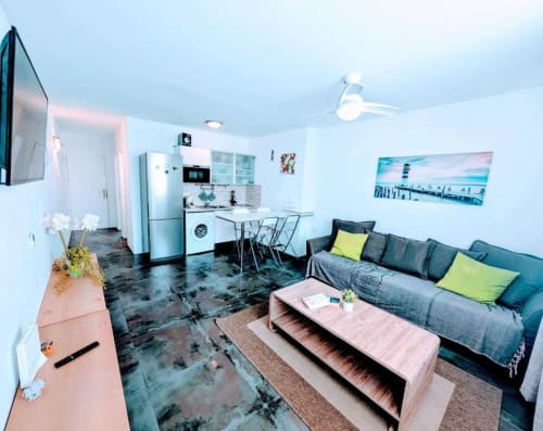 Modern studio apartment in Arona, Tenerife with open-plan living, gray sofa, kitchenette, and contemporary furnishings