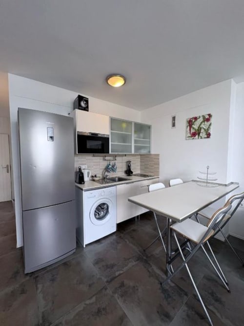 Modern kitchen-dining area at Manage Home Tenerife apartment in Arona with stainless steel appliances and breakfast table