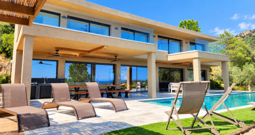 Villa Aria Terra aux Villas d'A Storia à Pinarellu : terrasse moderne au bord de la piscine avec transats et vue sur mer