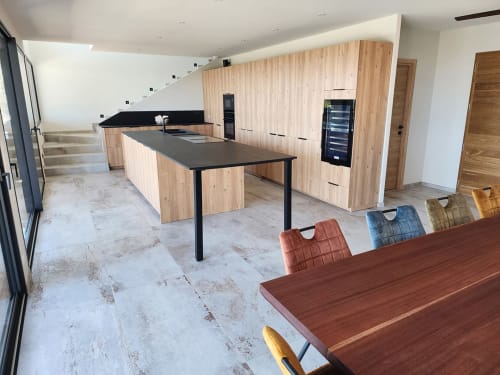 Cuisine moderne de la Villa Aria Terra aux Villas d'A Storia, Pinarellu, avec meubles en bois clair et plan de travail noir