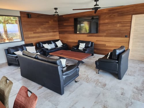 Salon de villa moderne avec sièges en cuir noir, murs en bois, télévision et vue sur mer aux Villas d'A Storia, Pinarellu