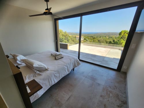 Chambre moderne de la Villa Aria Terra aux Villas d'A Storia avec vue mer, ventilateur de plafond et accès à la terrasse