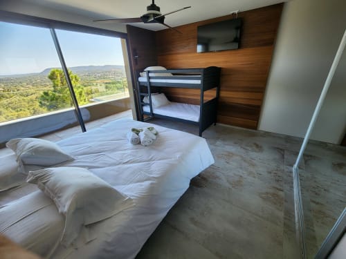 Chambre moderne aux Villas d'A Storia avec lit queen, lits superposés, vue montagne, ventilateur et TV écran plat