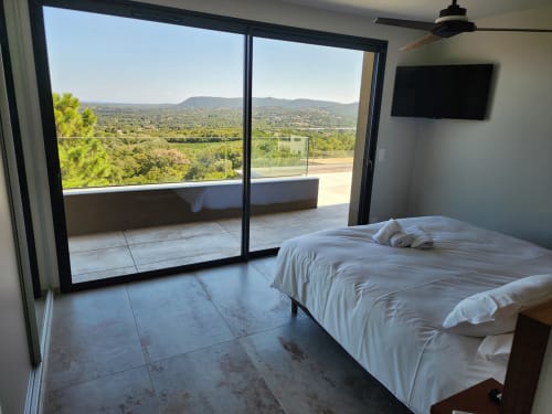 Chambre de la Villa Aria Terra à Pinarellu, avec terrasse vue mer, lit moderne, télévision écran plat et paysage montagneux