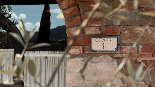 Targhetta dell'appartamento Cosimo su muro in laterizio presso il Borgo di Erboli B&B a Cavriglia, Italia