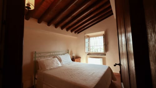 Appartamento Cosimo a Borgo di Erboli a Cavriglia con letto, travi in legno, finestra e arredamento rustico