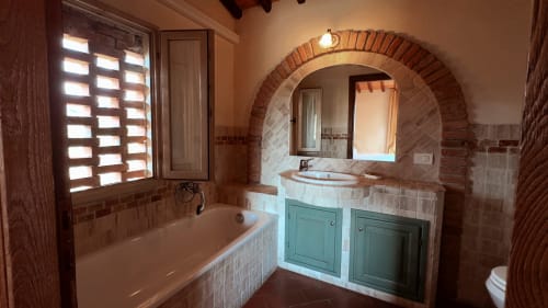 Ampio bagno nell'appartamento Cosimo a Borgo di Erboli, Cavriglia, con vasca, lavabo, specchio ad arco e stile rustico