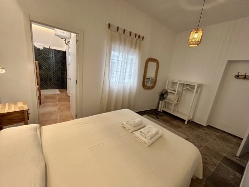 Dormitorio espacioso en apartamento Judería1, Sevilla con cama blanca, luz natural y acceso a baño privado