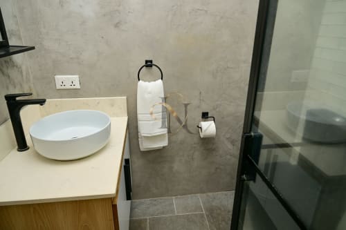 Salle de bains moderne de la villa Nora à Gerards & Angel, Grand Baie : vasque blanche, robinetterie noire et murs en marbre