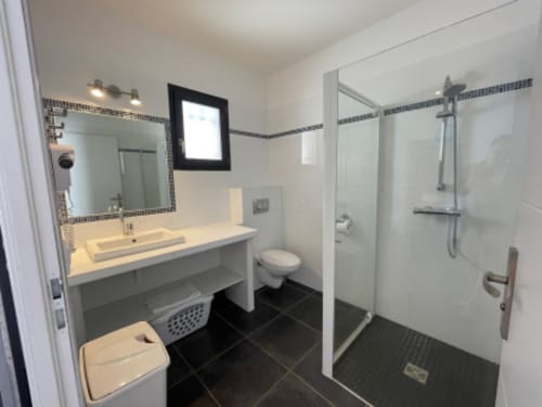 Salle de bain moderne aux Villas d'A Storia avec double vasque, douche vitrée et carrelage noir