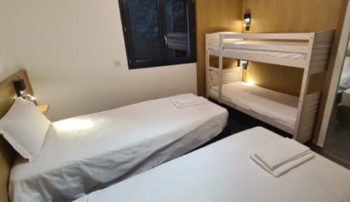 Chambre contemporaine aux Villas d'A Storia à Zonza avec lit queen, lits superposés blancs et vue sur mer