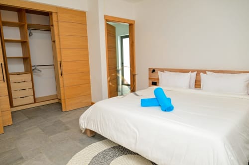 Chambre moderne à la villa Gerards & Angel à Grand Baie avec mobilier en bois, lit blanc et serviettes bleues