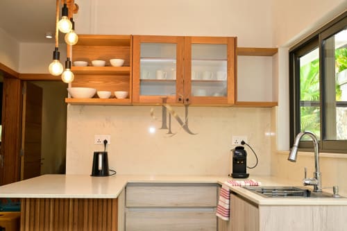 Cuisine moderne de la villa Nora à Gerards & Angel, Grand Baie, avec armoires en bois, évier en acier inoxydable et suspension