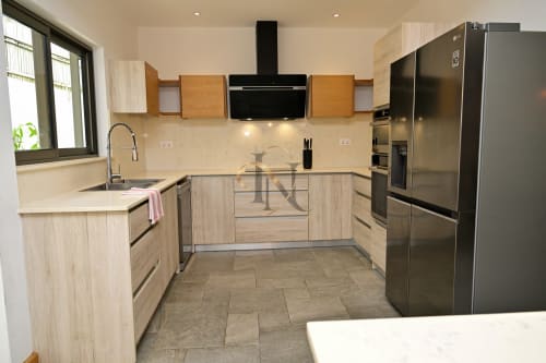 Cuisine moderne à la villa Nora, Gerards & Angel, Grand Baie, avec meubles en bois clair, électroménagers inox et crème