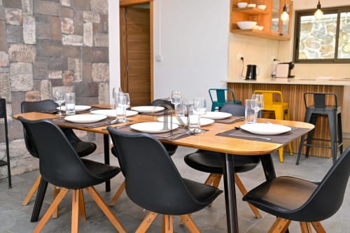 Salle à manger contemporaine de la villa Nora à Gerards & Angel, Grand Baie avec table en bois, chaises noires et cuisine visible