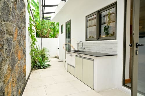 Cuisine extérieure moderne à la villa Gerards & Angel à Grand Baie avec cuisinière à gaz en acier inoxydable, évier et verdure luxuriante