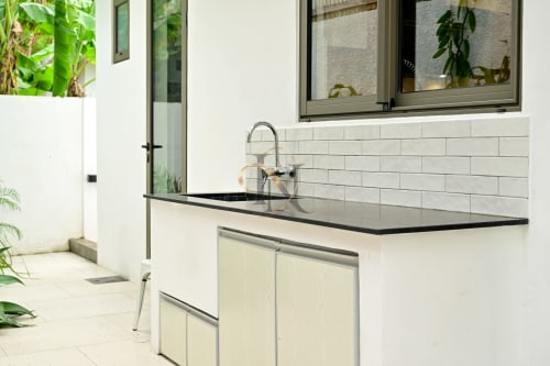 Cuisine extérieure moderne à la villa Gerards & Angel à Grand Baie avec plan de travail noir, évier en acier inoxydable et carrelage blanc