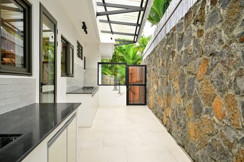 Cuisine moderne et patio extérieur de la villa Nora à Gerards & Angel, Grand Baie, avec murs en pierre et puits de lumière