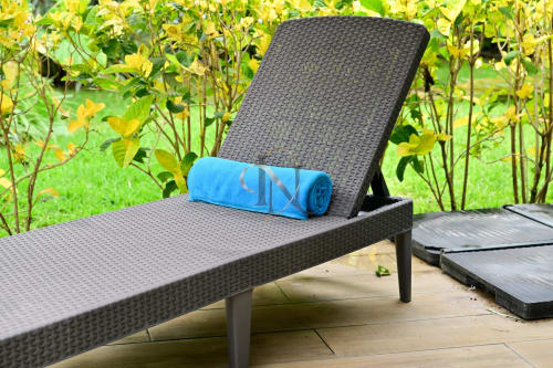 Chaise longue extérieure avec serviette bleue à la villa Gerards & Angel à Grand Baie, vue sur le jardin
