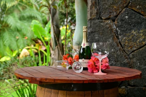 Bouteille de champagne et verres avec fleurs roses sur table en bois, vue sur le jardin luxuriant de la villa Gerards & Angel, Grand Baie