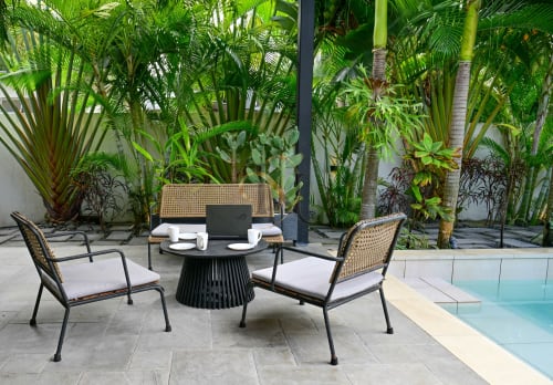 Terrasse piscine tropicale chez Gerards & Angel avec salon, table ronde noire et jardin de palmiers à Grand Baie.