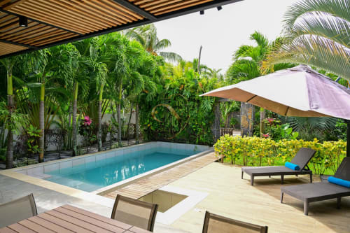 Piscine de luxe à Gerards & Angel, Grand Baie avec eau turquoise, transats, plantes tropicales et parasol violet