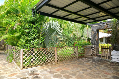 Patio tropical de la villa Gerards & Angel à Grand Baie avec clôture ajourée, palmiers et pergola moderne