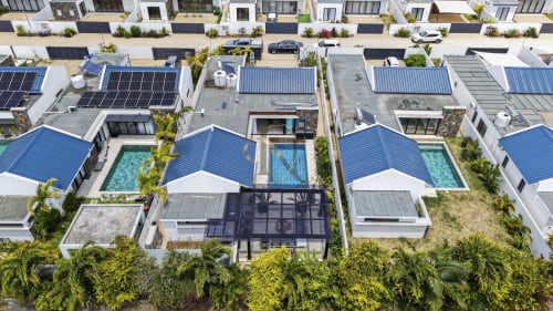Vue aérienne de la villa Gerards & Angel avec piscine, toit bleu, panneaux solaires et jardin tropical à Petit Raffray