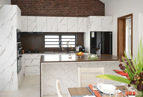 Cuisine moderne avec cabinetry en marbre, appareils noirs et coin repas à la villa Gerards & Angel à Maurice