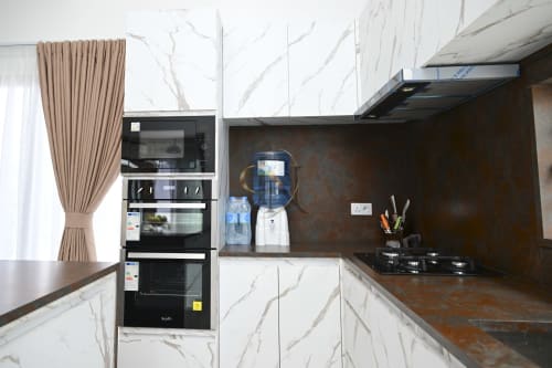 Cuisine moderne avec comptoirs en marbre, appareils noirs et dosseret foncé à la villa Gerards & Angel à Maurice