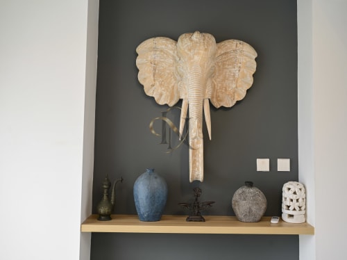 Tête d'éléphant sculptée en bois au-dessus d'une étagère décorée à la villa Gerards & Angel à Maurice