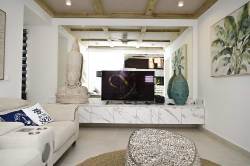 Salon moderne de villa chez Gerards & Angel avec centre de divertissement en marbre, TV écran plat, canapé blanc et décor tropical