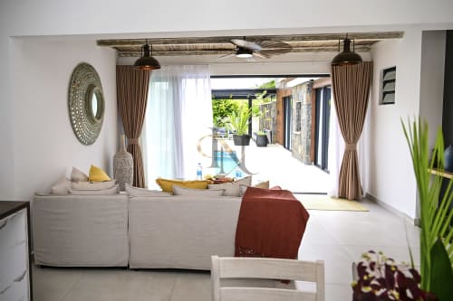 Espace de vie ouvert de la villa Gerards & Angel avec salon, salle à manger, vue piscine par portes vitrées et décor rustique moderne