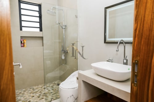 Salle de bain moderne de la villa Gerards & Angel avec vasque, douche à effet pluie, toilettes et miroir lumineux