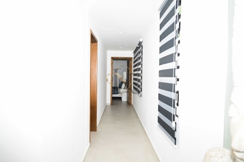 Couloir moderne aux murs blancs et porte-serviettes rayé à la Villa Coin des Zils n°5, Gerards & Angel