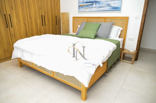 Chambre moderne avec lit à barreaux en bois, literie verte et tête de lit en rotin à la villa Gerards & Angel, Petit Raffray